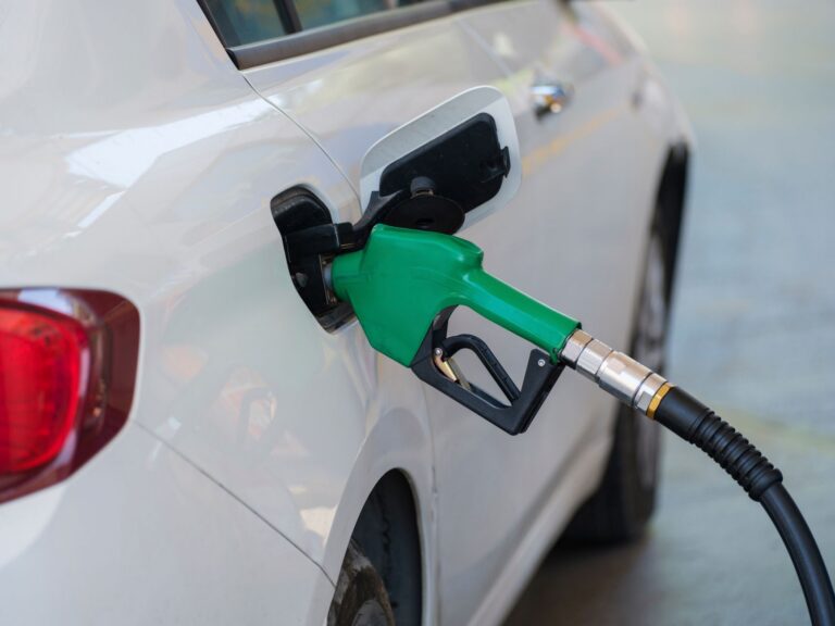 Conductor repostando en una gasolinera mientras se plantea cuánto va a subir la gasolina