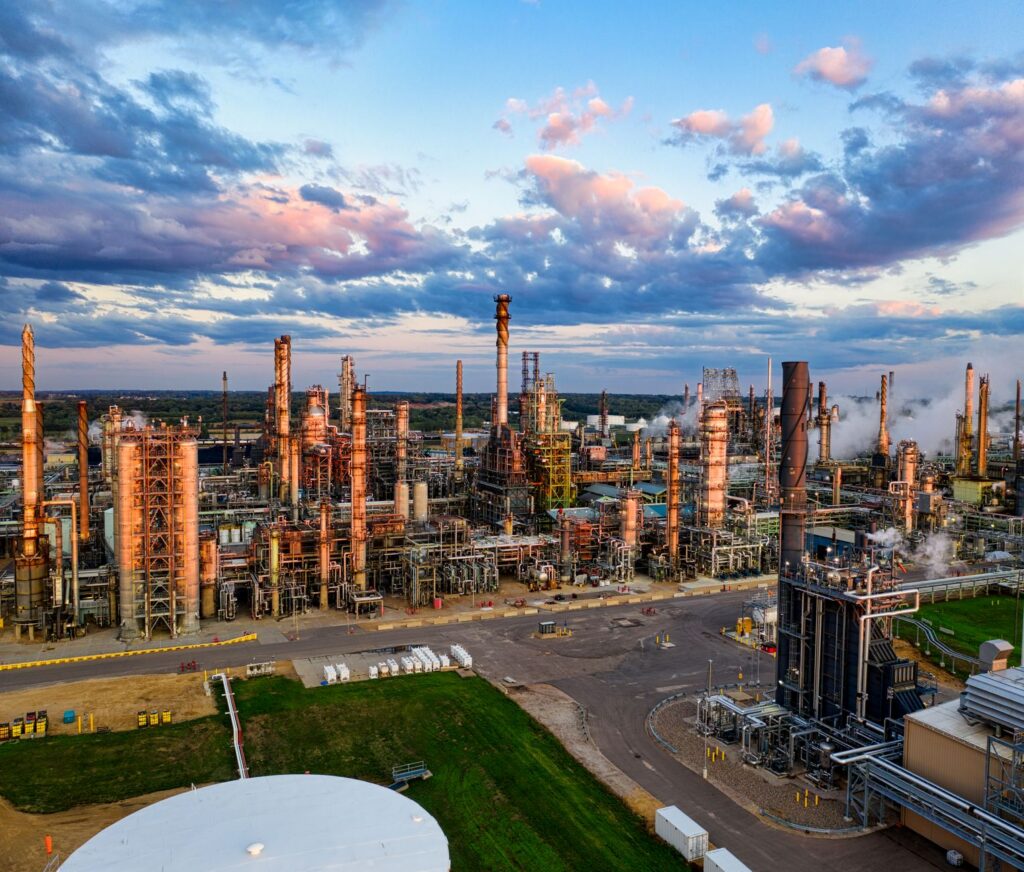Refinería de petróleo al atardecer, con el precio del petróleo Brent en octubre de 2026 por debajo de 115 dólares